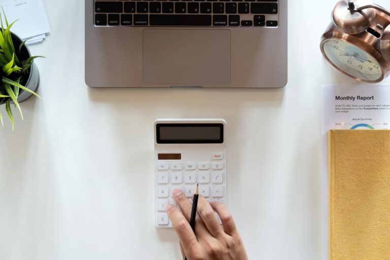 Top view hand of accountant using calculator on workplace with copy space, calculator and plant